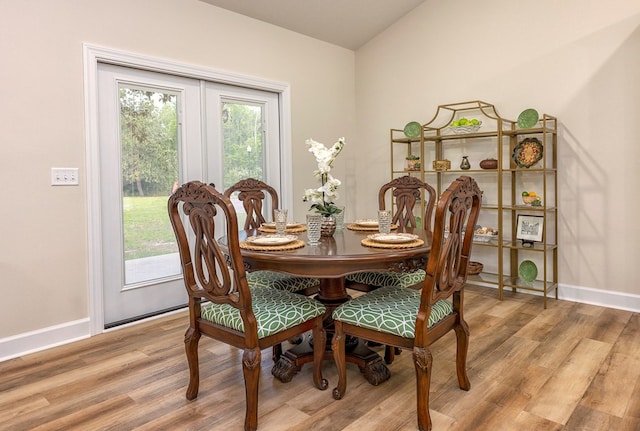 dining space featuring light hardwood / wood-style floors and vaulted ceiling