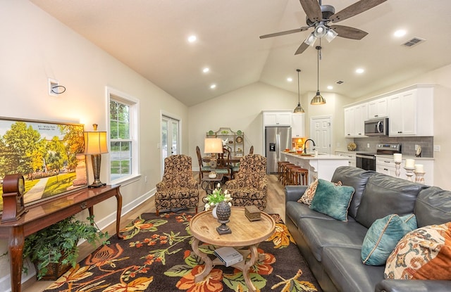 living room featuring hardwood / wood-style floors, ceiling fan, lofted ceiling, and sink