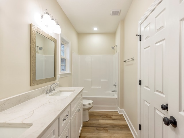 full bathroom with hardwood / wood-style floors, vanity, toilet, and bathtub / shower combination