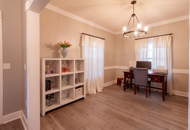 office space with light wood finished floors, baseboards, a chandelier, ornamental molding, and a textured ceiling