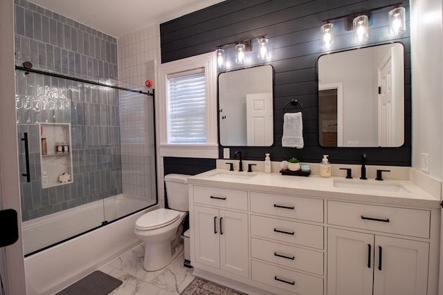 full bath featuring combined bath / shower with glass door, marble finish floor, toilet, and a sink