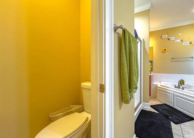 bathroom with tile patterned flooring, a tub to relax in, crown molding, and toilet