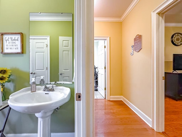 bathroom with ornamental molding and wood-type flooring