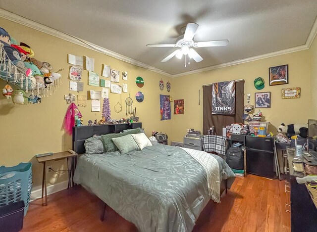 bedroom featuring hardwood / wood-style flooring, ornamental molding, and ceiling fan