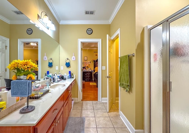 bathroom featuring tile patterned flooring, ornamental molding, vanity, and a shower with shower door