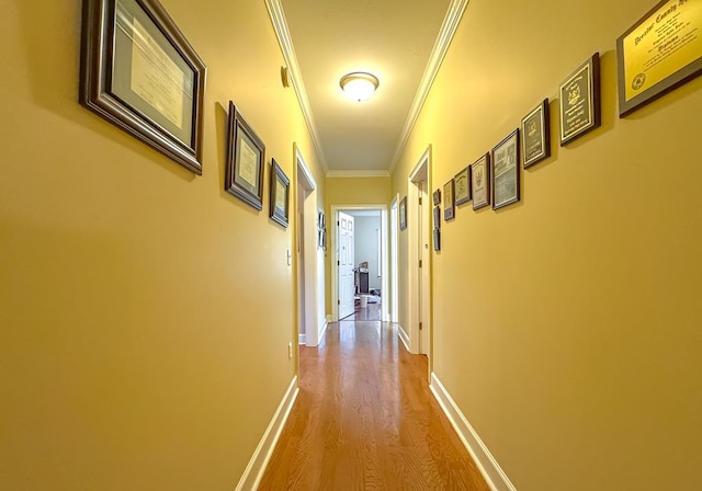 corridor with crown molding and light hardwood / wood-style floors