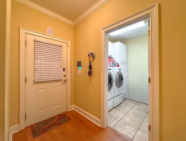 laundry room featuring cabinets, crown molding, separate washer and dryer, and light wood-type flooring