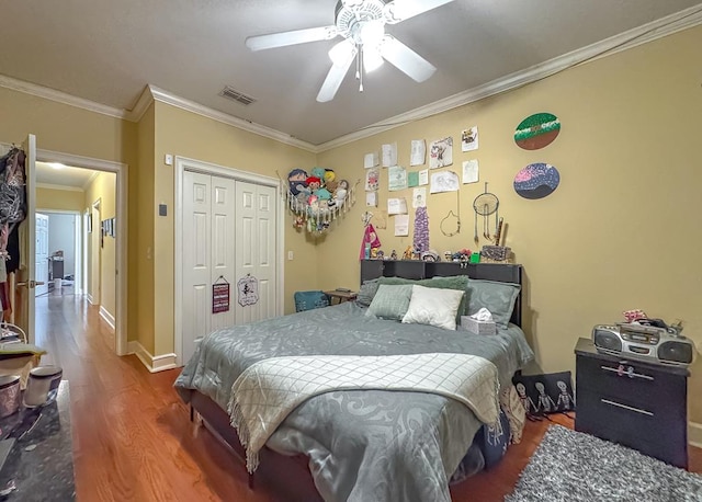 bedroom featuring hardwood / wood-style floors, crown molding, a closet, and ceiling fan