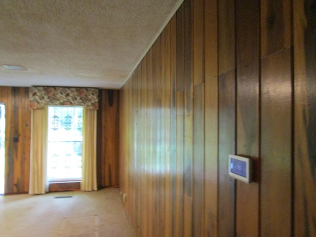 spare room with wood walls and a textured ceiling