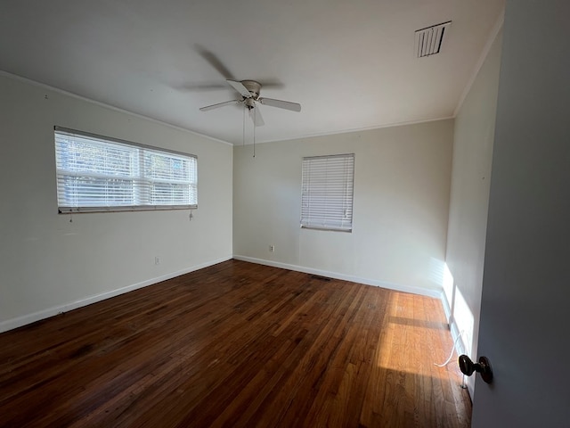 spare room with dark wood-type flooring, ceiling fan, and ornamental molding