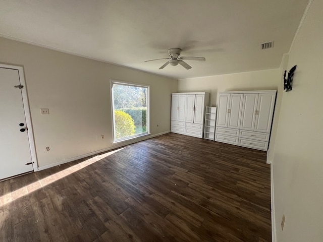 unfurnished bedroom with ceiling fan and dark wood-type flooring