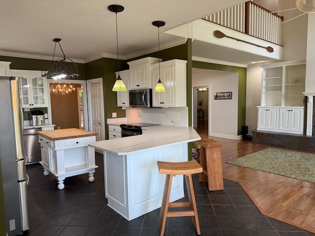 742 Booster Club Rd, Bainbridge, GA 39819 - kitchen with stainless steel appliances, wooden counters, white cabinets, dark tile patterned flooring, and a peninsula