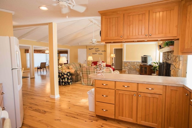 kitchen with light hardwood / wood-style flooring, ceiling fan, white refrigerator, lofted ceiling with beams, and kitchen peninsula