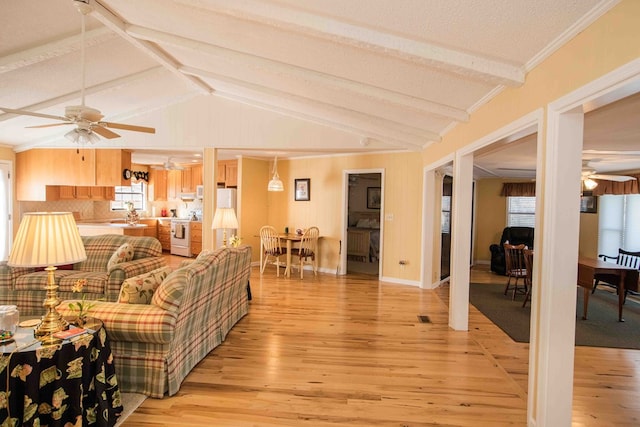 living room featuring ornamental molding, vaulted ceiling with beams, ceiling fan, and light hardwood / wood-style flooring