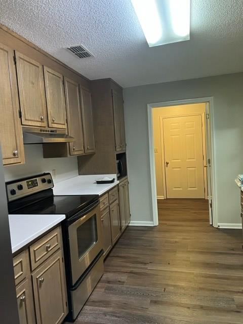 kitchen featuring a textured ceiling, dark hardwood / wood-style flooring, and stainless steel range with electric stovetop