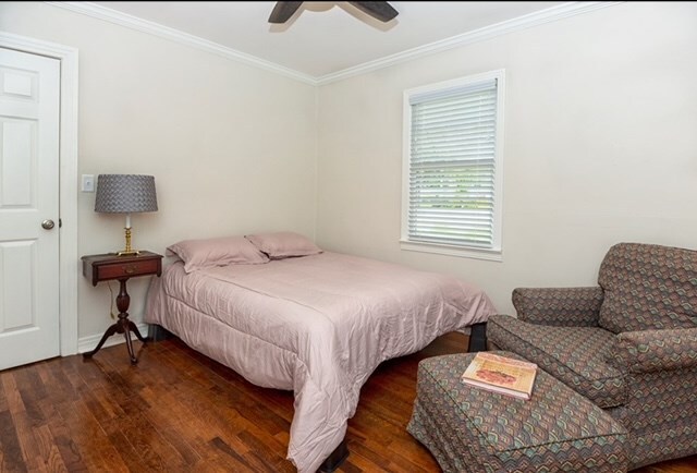 bedroom featuring dark hardwood / wood-style floors, ceiling fan, and crown molding