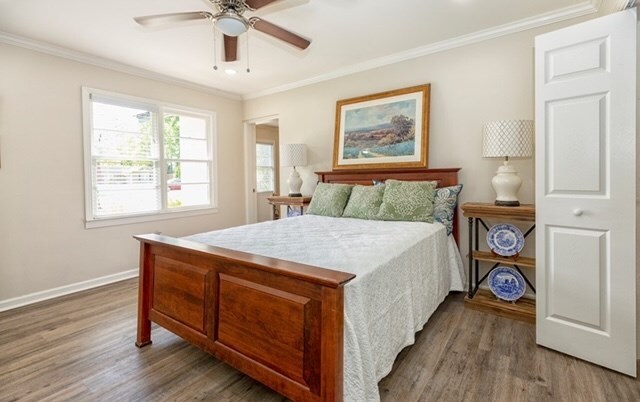 bedroom featuring hardwood / wood-style floors, ceiling fan, and crown molding