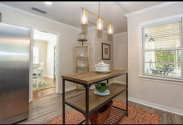 dining space featuring hardwood / wood-style flooring and crown molding