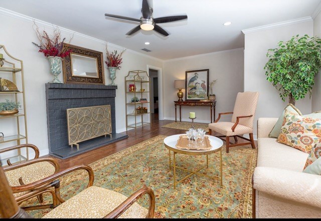 living room with wood-type flooring, ceiling fan, and crown molding