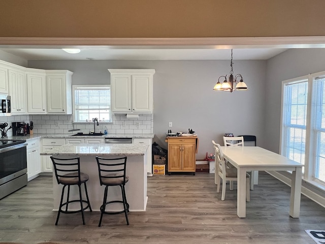 kitchen with a kitchen island, wood-type flooring, and white cabinetry