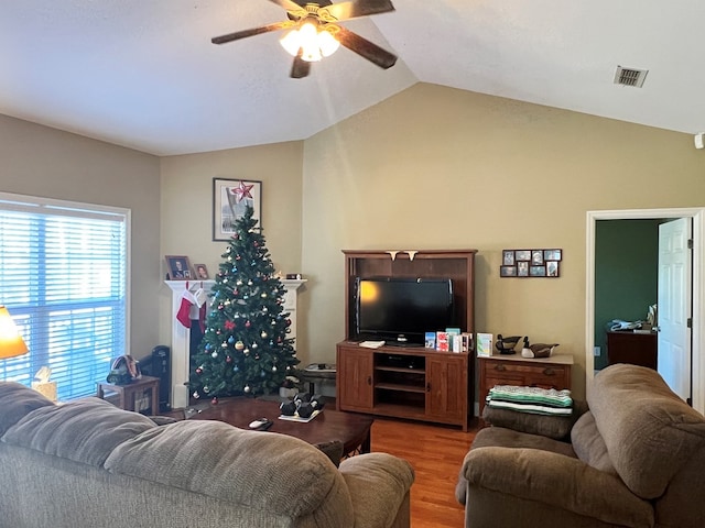 living room featuring ceiling fan, hardwood / wood-style floors, and vaulted ceiling