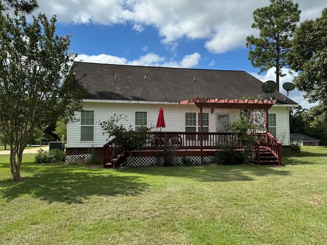 rear view of house featuring a lawn and a wooden deck