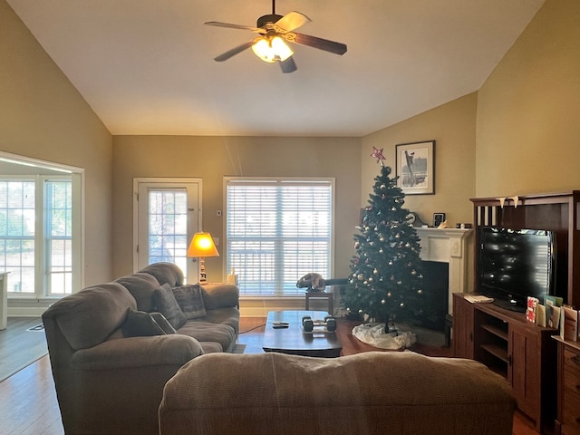 living room with ceiling fan, wood-type flooring, and lofted ceiling