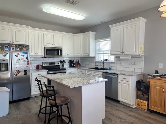 kitchen with white cabinets, a center island, and appliances with stainless steel finishes