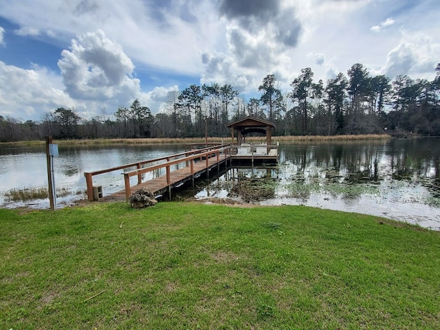 dock area featuring a lawn and a water view