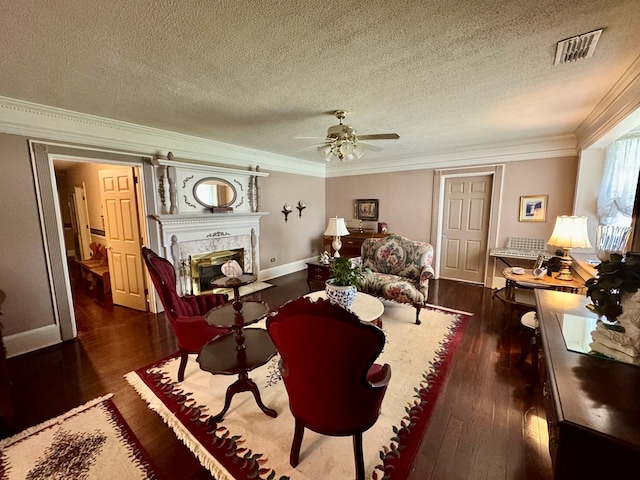 1001 Hall St, Bainbridge, GA 39819 - living room featuring dark wood-style flooring, ornamental molding, a fireplace, a textured ceiling, and ceiling fan
