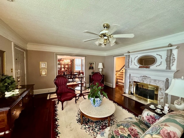 1001 Hall St, Bainbridge, GA 39819 - living room featuring wood finished floors, ceiling fan, a textured ceiling, crown molding, and a premium fireplace