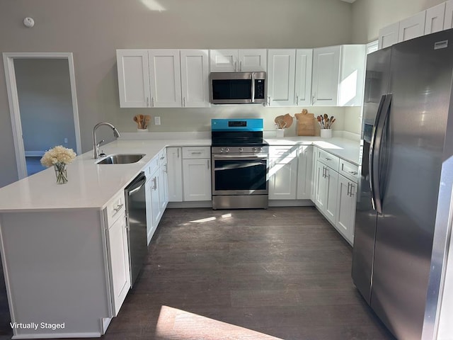 kitchen featuring appliances with stainless steel finishes, white cabinetry, and kitchen peninsula