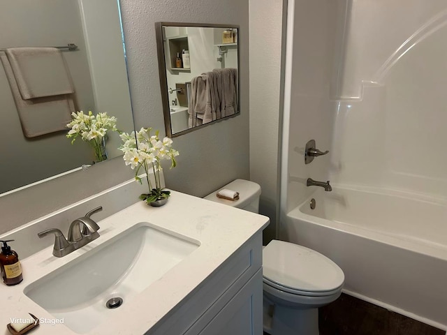 full bathroom featuring tub / shower combination, vanity, and toilet