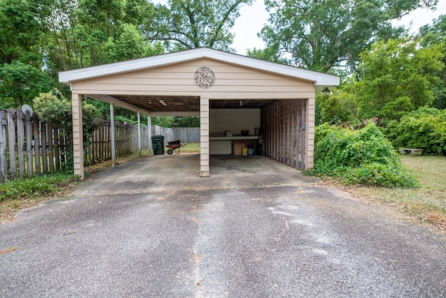 view of parking / parking lot with fence and driveway