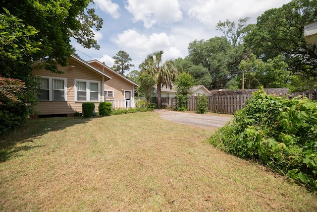 view of yard with fence and driveway