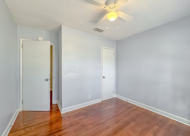 unfurnished bedroom with light wood-type flooring, a closet, a textured ceiling, and ceiling fan