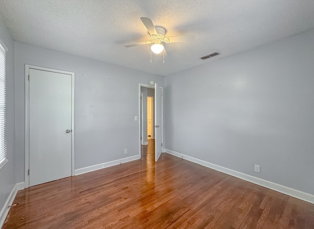 spare room with a textured ceiling, ceiling fan, and wood-type flooring