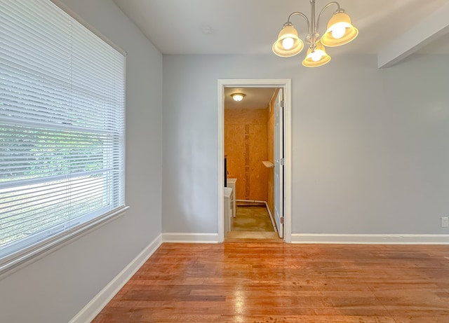 spare room with a chandelier and light hardwood / wood-style flooring