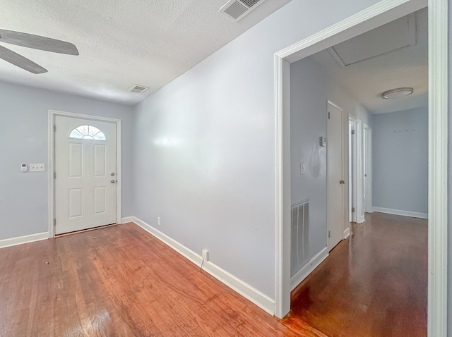 entryway with light hardwood / wood-style floors, ceiling fan, and a textured ceiling