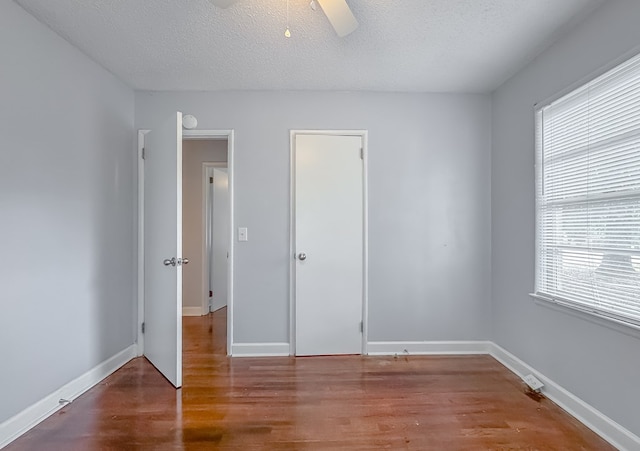 unfurnished bedroom featuring hardwood / wood-style flooring, ceiling fan, and a textured ceiling