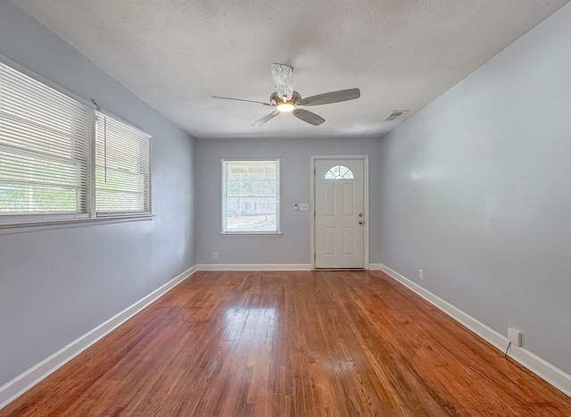 entrance foyer with light wood-type flooring, a textured ceiling, and ceiling fan