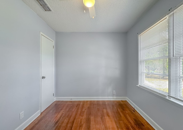 unfurnished room with wood-type flooring and a textured ceiling