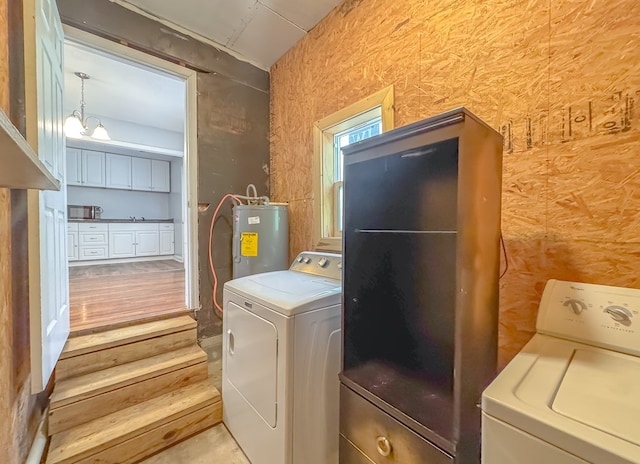 laundry room with water heater and separate washer and dryer