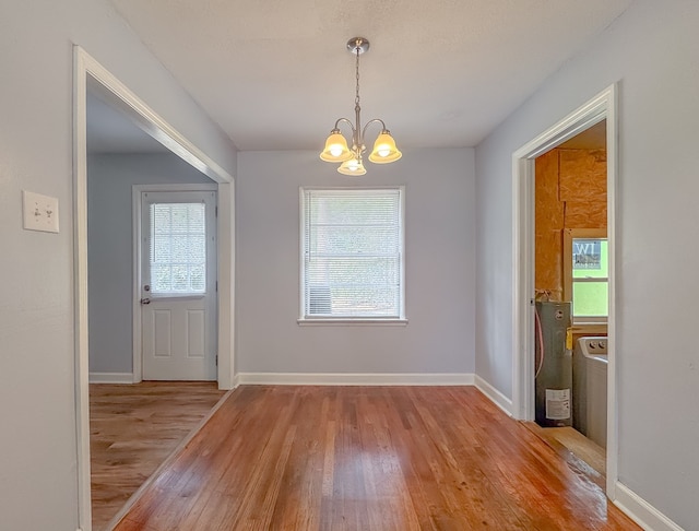 unfurnished dining area featuring light hardwood / wood-style floors and an inviting chandelier