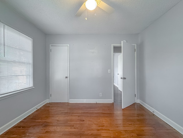 unfurnished bedroom with hardwood / wood-style floors, ceiling fan, and a textured ceiling