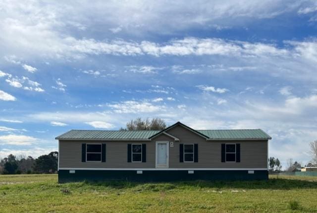 manufactured / mobile home with a front yard and metal roof