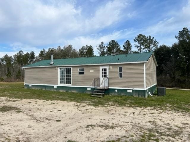 back of property featuring entry steps, metal roof, and central air condition unit