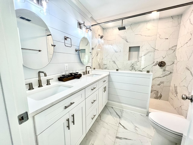 bathroom featuring a tile shower, vanity, and toilet