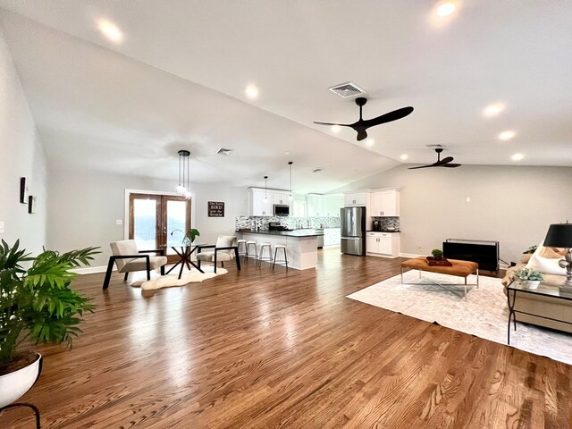 living room featuring dark wood-type flooring, ceiling fan, lofted ceiling, and french doors