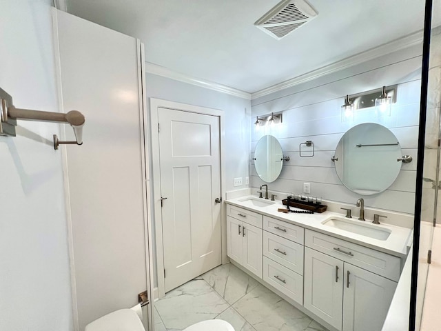 bathroom with vanity, crown molding, and toilet